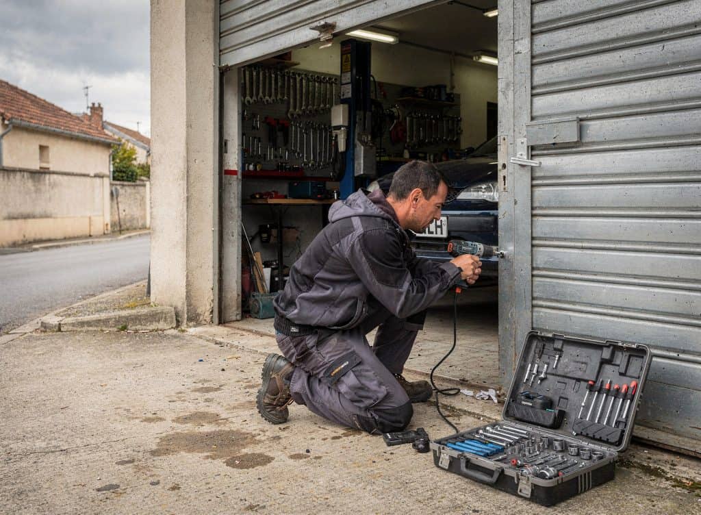 Serrurier à Perpignan utilisant un outil pour réparer une serrure dans un garage.