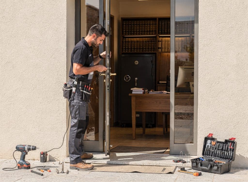 Serrurier à Perpignan installant une serrure de sécurité à la porte d'entrée.